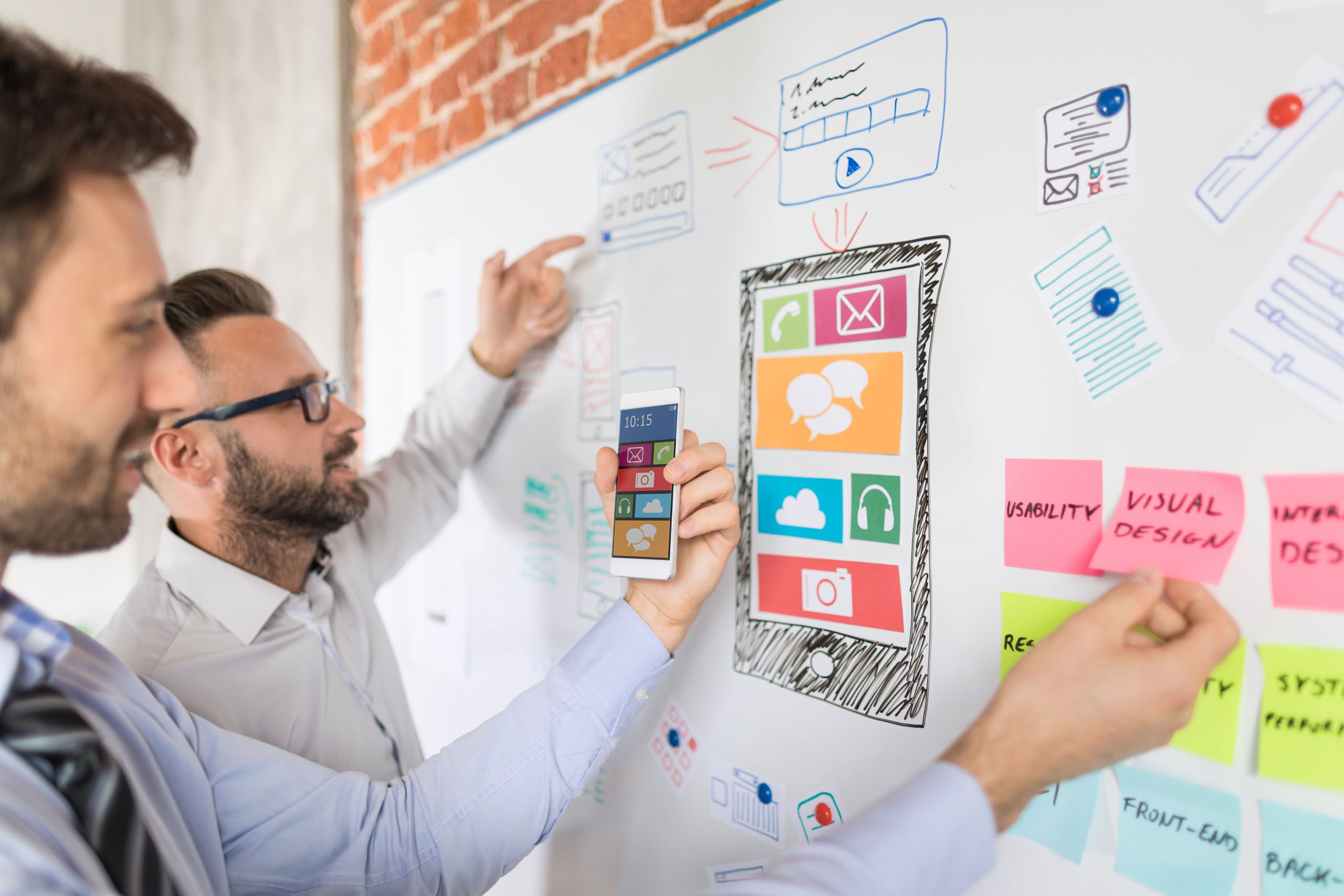 Designers mapping app screens on a whiteboard for the next era of interfaces