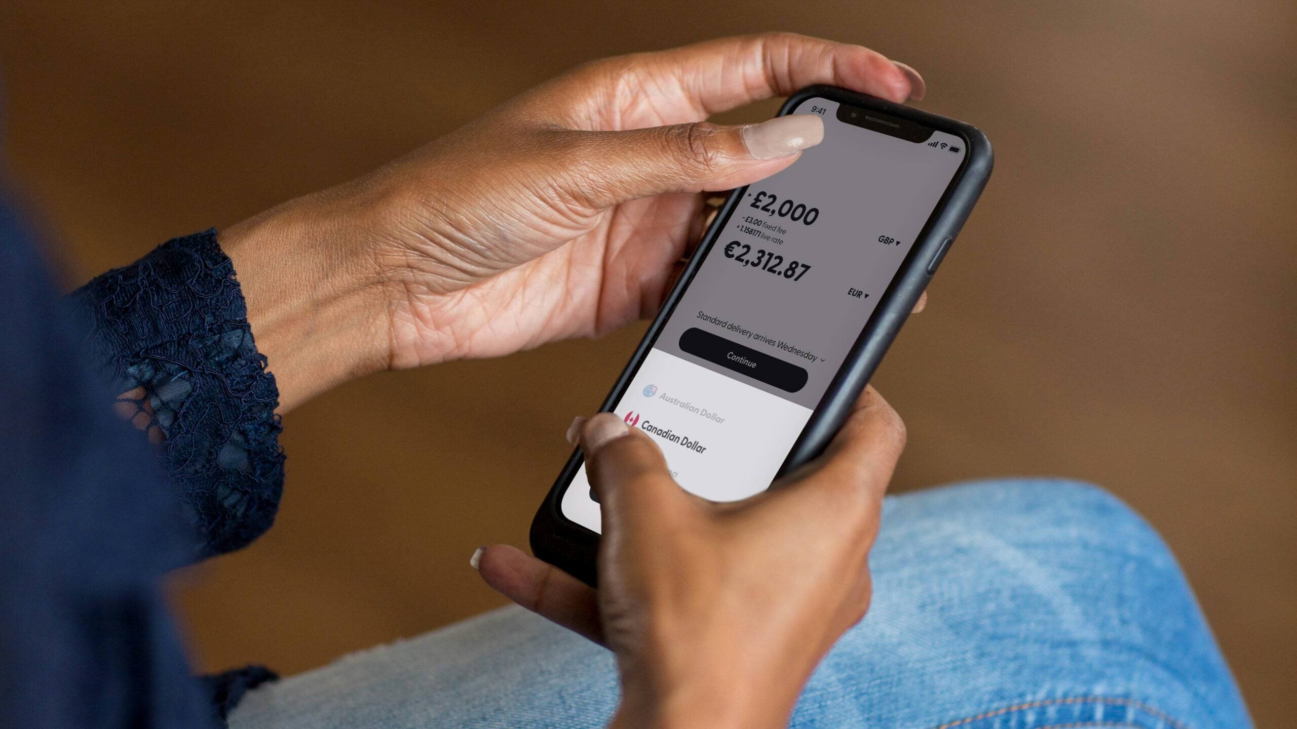 Smartphone money transfer app showing GBP to EUR exchange: £2,000 to €2,312.87
