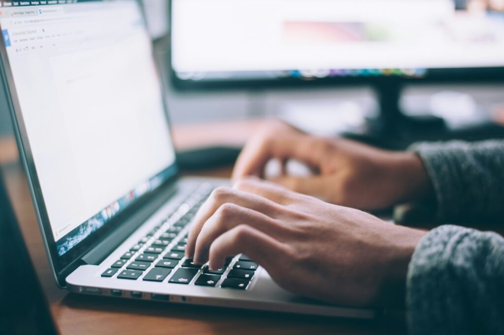 Person on a laptop, keeping progress going while tackling digital debt