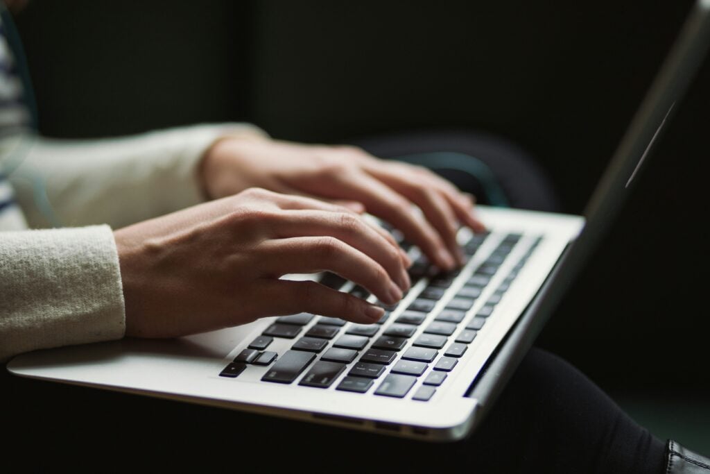 Person typing on a laptop, illustrating why digital products fail without adoption