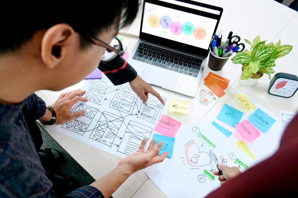 Designer sketching wireframes while reviewing which features add value