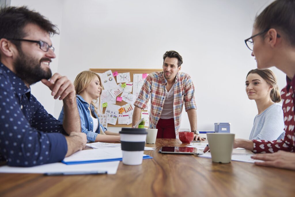 Team discussion around a meeting table, getting past a lack of buy-in